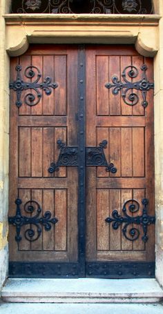 two wooden doors with wrought iron designs on them