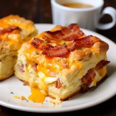 two pieces of breakfast casserole on a plate next to a cup of coffee