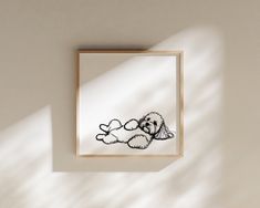 a black and white drawing of a dog laying on it's back in a frame