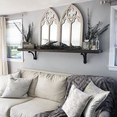 a living room filled with furniture and decor on top of a window sill next to a white couch