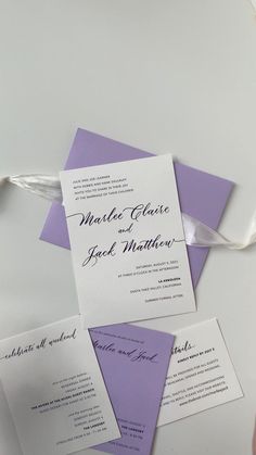 the wedding stationery is laid out on top of each other