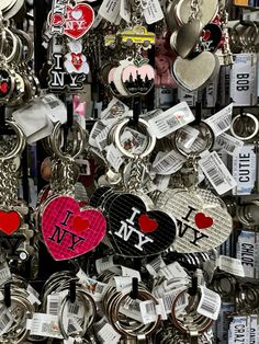 many different types of key chains hanging on a wall with i love ny tags attached to them