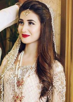 a woman in a bridal outfit posing for the camera