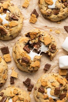 chocolate chip cookies and marshmallows are on parchment paper