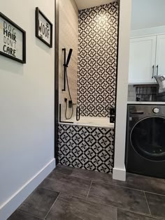 a washer and dryer in a bathroom with black and white wallpaper on the walls