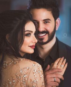 a man and woman are smiling at each other while they pose for a photo together