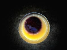 an overhead view of a drink in a glass on a black table with dark background