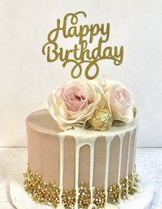 a birthday cake with white frosting and pink roses on top is decorated with gold glitters