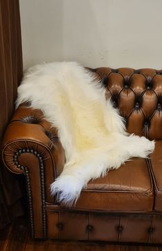 a brown leather couch with white fur on it