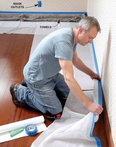 a man laying on the floor next to a sheet of white paper with blue tape