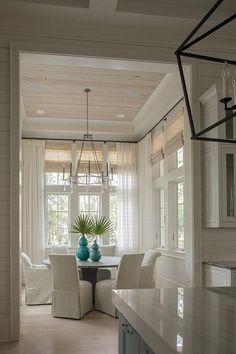 a dining room table with chairs and vases on it