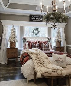 a bedroom decorated for christmas with white and red decorations on the windowsill, plaid bedding