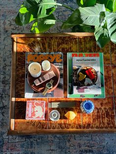 an overhead view of a tray with coffee, magazines and other items sitting on it