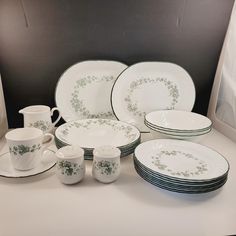 a white table topped with lots of plates and cups