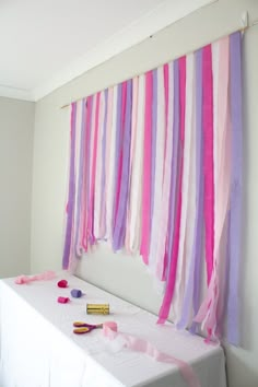 a white table topped with lots of pink and purple streamers