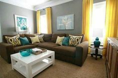 a living room filled with furniture and yellow drapes