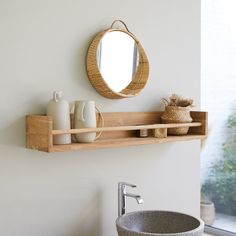 a bathroom with a sink, mirror and vase on the shelf next to the window