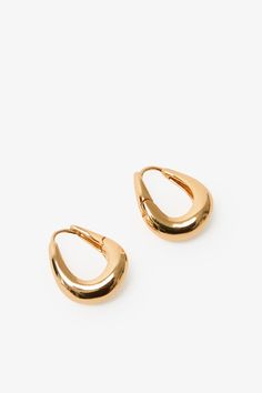 Find poetry in the everyday with our Sisley Hoops. Elegant and ever-so-chunky, these oval ornaments are crafted from sterling silver with either 18k gold or white gold plating to complement any look. Featuring a post back closure and polished finish. Each pair includes a Marcella-branded vegan leather travel case for safe storage and easy travel. | Available in one size. Approximately .5” (1.5 cm) in height, and .3" (.8 cm) in width. In silver, white gold plated sterling silver. In gold, 18KT ye Everyday Oval Jewelry With Shiny Finish, Oval Jewelry With Shiny Finish For Everyday, Everyday Teardrop Jewelry With Shiny Finish, Classic Everyday Jewelry With Rounded Edges, Trendy Oval Jewelry For Everyday, Trendy Oval Jewelry For Formal Occasions, Elegant Everyday Jewelry, Safe Storage, Easy Travel