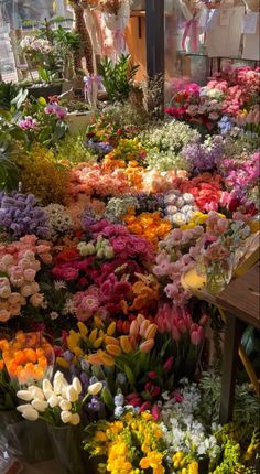 many different colored flowers are on display in a flower shop