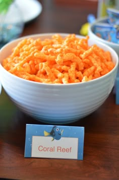 a bowl filled with cereal sitting on top of a table next to a sign that says coral reef