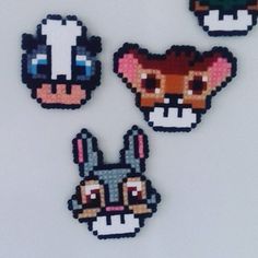 four pixelated animal head magnets on a white surface