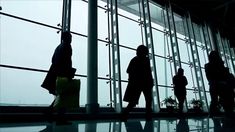 silhouettes of people walking in an airport terminal