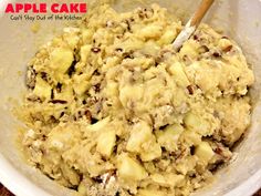 an apple cake is in a bowl with a wooden spoon