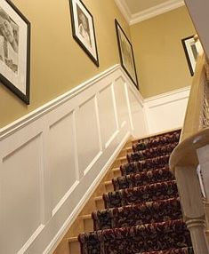 a staircase with pictures on the wall and carpet