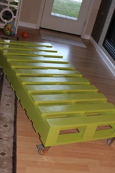 a green bed frame sitting on top of a hard wood floor next to a door