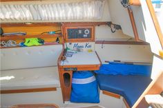 the inside of a sailboat with a small table and blue storage bag on it