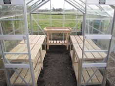 the inside of a greenhouse with benches and tables