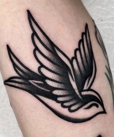 a black and white bird tattoo on the arm