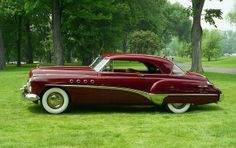 an old fashioned car parked in the grass