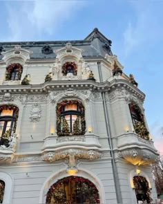 a large white building with christmas decorations on the windows