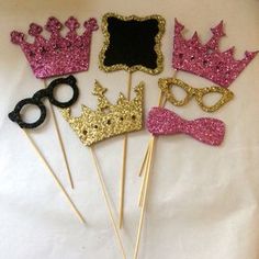 there are some pink and black glittered items on sticks