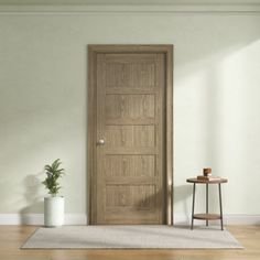 an empty room with a wooden door and potted plant on the floor next to it