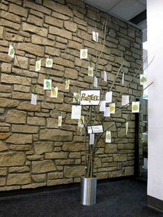 there is a tree that has been decorated with post - it notes on the wall