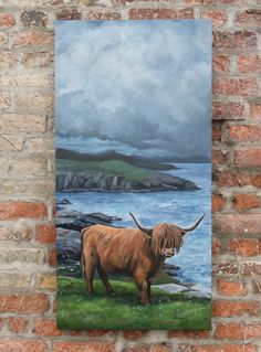 a painting on a brick wall with a cow standing in the grass by the water