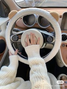 a person driving a car with their hands on the steering wheel and wearing white gloves