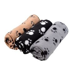 three different colored dog paw prints on black, white and grey blankets folded in rows