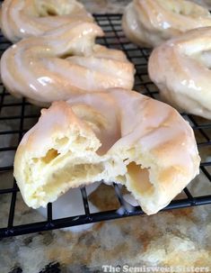 several glazed donuts are cooling on a rack