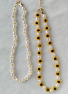 two necklaces with yellow and white beads