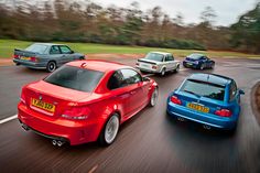 three different colored cars driving down the road together, one is blue and one is red