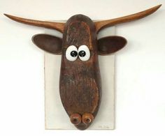 a wooden wall hanging with an animal's head and eyes