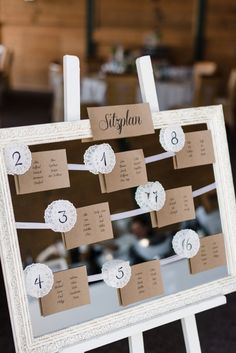 a white frame with some brown paper on it and numbers attached to the side of it