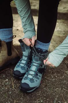 someone tying up their hiking shoes on the ground