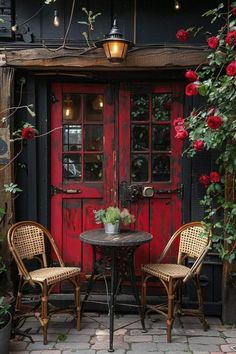 two chairs and a table in front of a red door