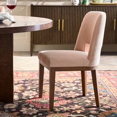 a dining room table with a glass of wine on it and a rug in the background