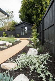 an image of a garden with rocks and plants in the foreground text reads we love our @ thickeshed studio space