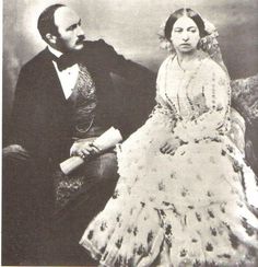 an old black and white photo of a man and woman sitting next to each other